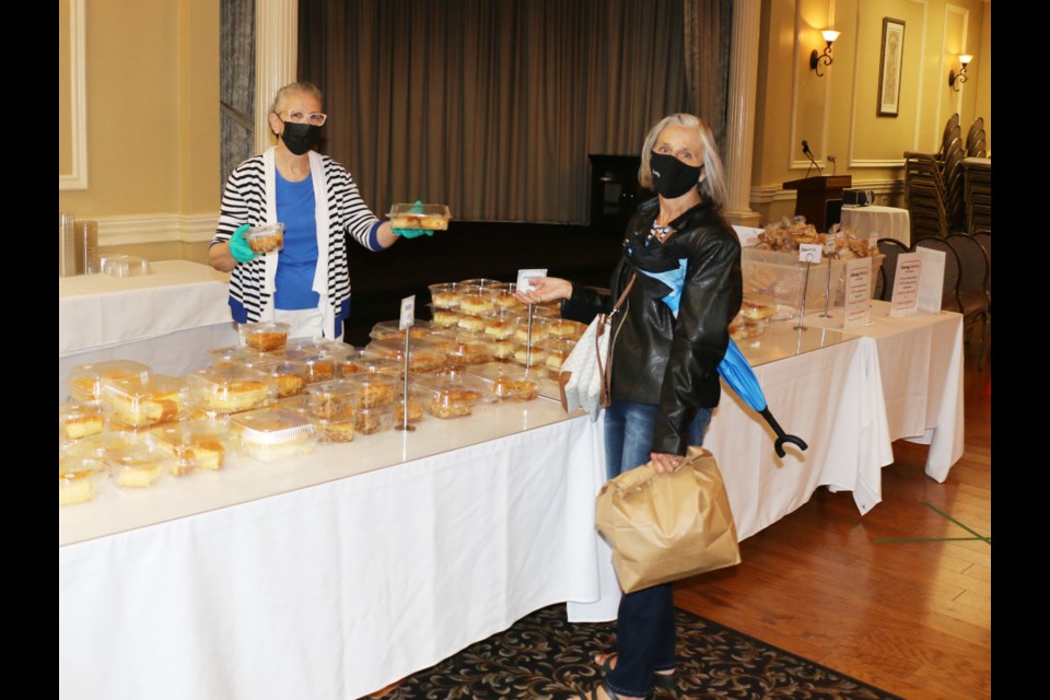 Customers at the annual Sudbury Greek Festival were pleased to see a solid selection of pastries at the dessert table at the Hellenic Centre.  Helen Koutsoukis, left, was serving sweet, custardy treats to Rachel Guy Saturday afternoon.   (Len Gillis / Sudbury.Com)
