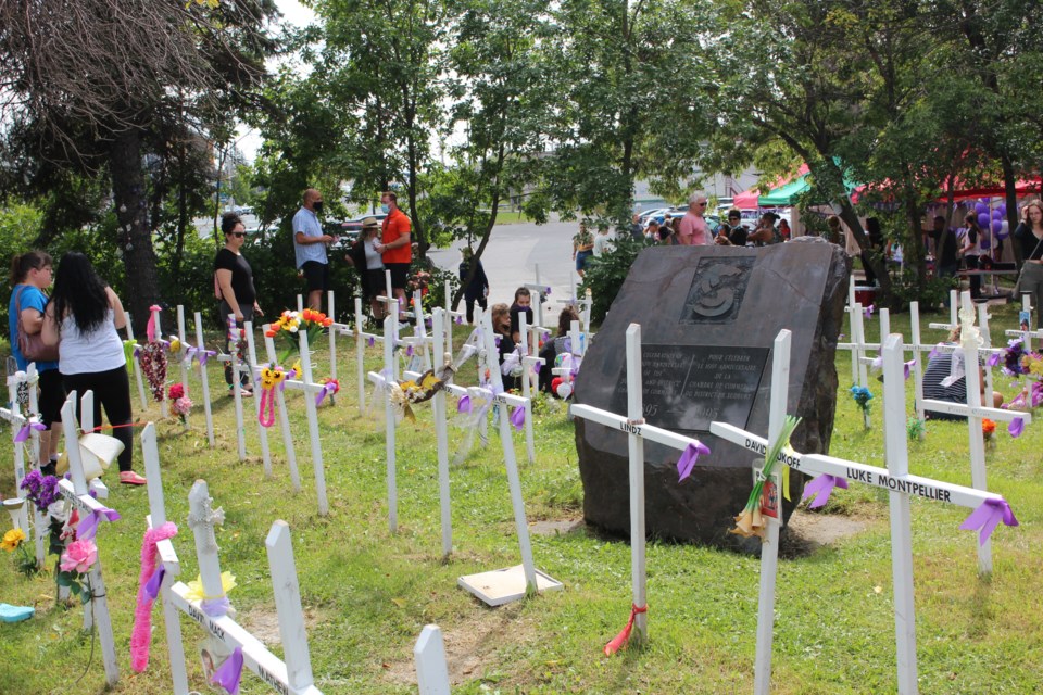 Families and friends gather at the Crosses for Change memorial in downtown Sudbury Sunday.