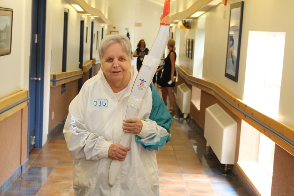 Finlandia resident Betty Saaski carried an Olympic torch from the 2010 Vancouver Winter Games to help kick off the Finlandia Summer Games Friday morning. Photo by Jonathan Migneault.