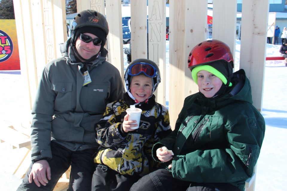 Dale Kelly and sons Jonathan, 7, and Nicholas, 11, enjoyed some hot chocolate and snacks Feb. 8 while resting in an ice station created by McEwen School of Architecture students. (Heidi Ulrichsen/Sudbury.com)