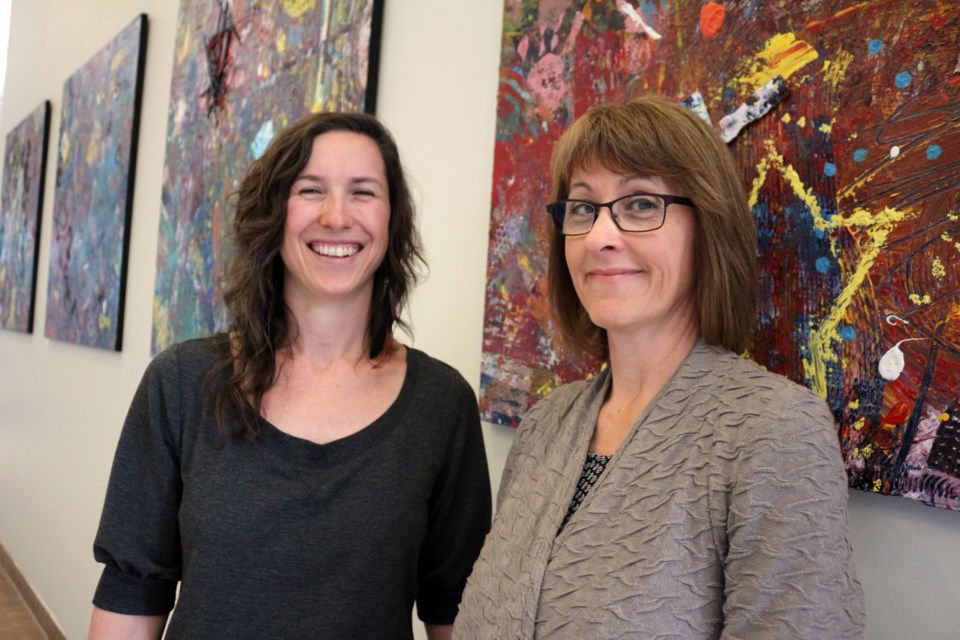 Artist Sarah King Gold of Myths and Mirrors (left) and New Sudbury Centre's marketing director, Brenda Folz, unveiled a community-generated painting, which is now on display in the hallway near Walmart. Photo by Heather Green-Oliver.