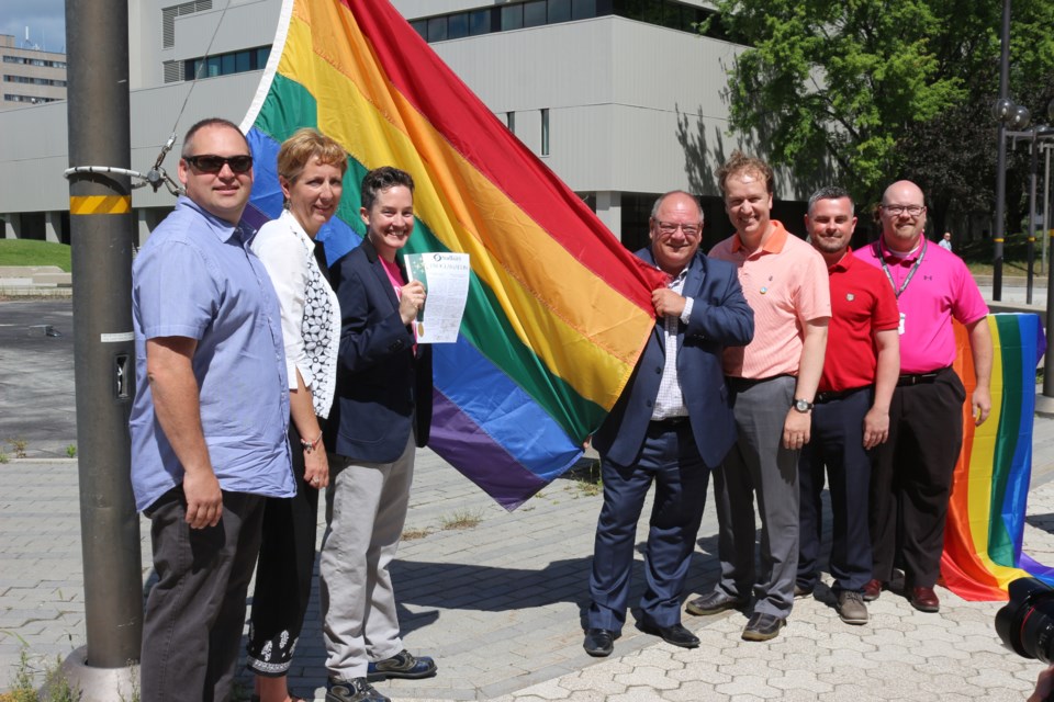 Fierté Sudbury Pride held a flag raising ceremony Monday morning to kick off Sudbury Pride Week. Pictured left to right are Ward 6 Coun. Rene Lapierre, Nickel Belt MP France Gélinas, Katherine Smith, chair of Fierte Sudbury Pride, Mayor Brian Bigger, Sudbury MP Paul Lefebvre, Darrell Marsh, representing MPP Glenn Thibeault's office, and Ward 7 councillor Mike Jakubo. Photo by Heather Green-Oliver.