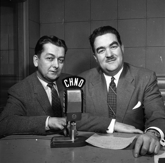 Baxter Ricard (right), owner and manager of radio stations CHNO AM and CFBR AM, with station manager René Riel on the first CFBR went on the air. (City of Greater Sudbury Archives)