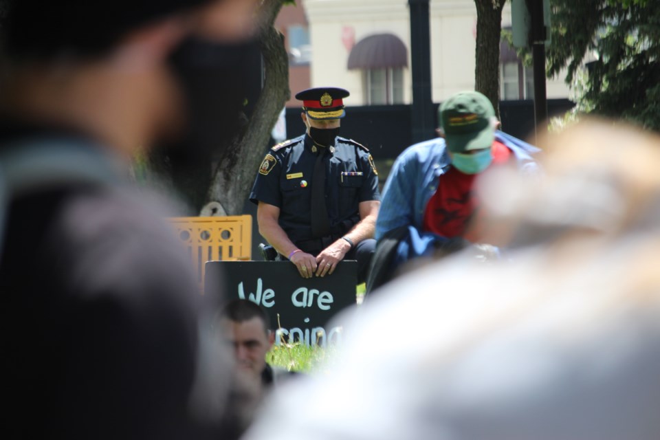 Holding a sign that reads ‘We are listening,’ Greater Sudbury Police Chief Paul Pedersen bows his head in reflection during an anti-police brutality protest in Memorial Park in Sudbury on June 3. (Arron Pickard / Sudbury.com)