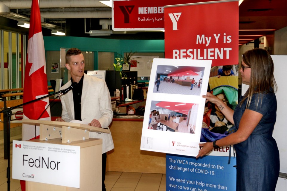 McEwen Faculty of Architecture third-year student Siah Klassen talks about the design for the YMCA Sudbury’s new front desk at 140 Durham Street during a FedNor funding announcement on Wednesday as YMCA of Northeastern Ontario VP of health and wellness Kendra MacIsaac holds the design.