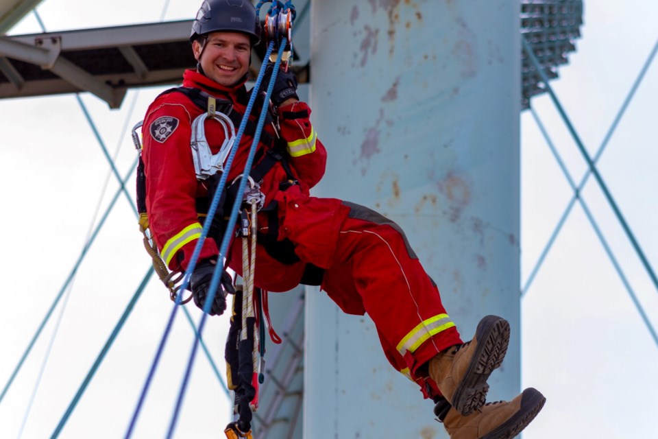 Jean Larocque, a firefighter with the Greater Sudbury Fire Services is lowered from the Sudbury water tower at an angle to a parking lot below in a rope system called a skate block.