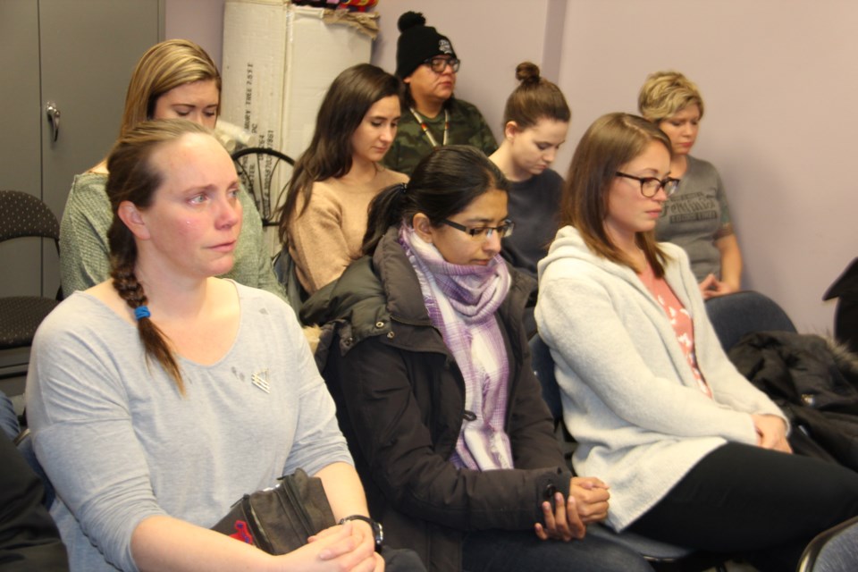 Participants in a memorial event on the 30th anniversary of the Montréal Massacre take part in a moment of silence. (Heidi Ulrichsen/Sudbury.com)