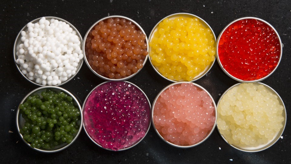 Colourful pearls made with a spherificator. Flavours are: (top row, from left) coconut, salsa, mango and raspberry; (second row, from left) mint, cherry, pickled ginger, and ginger. (Image: John Placko)