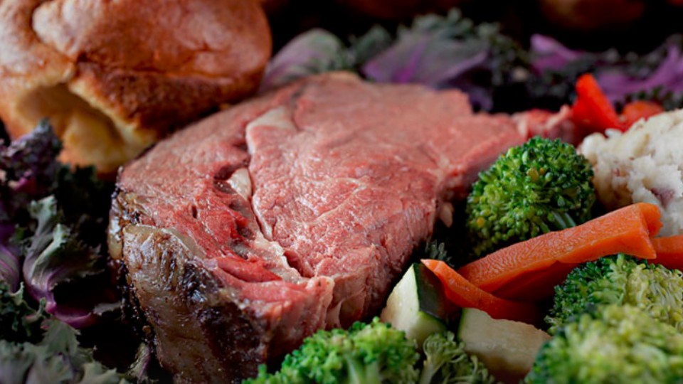 The Mr. Prime Rib King cut served with steamed vegetables and Yorkshire pudding and gravy.  Yorkshire pudding is an egg batter baked pop-over served typically with beef and gravy.