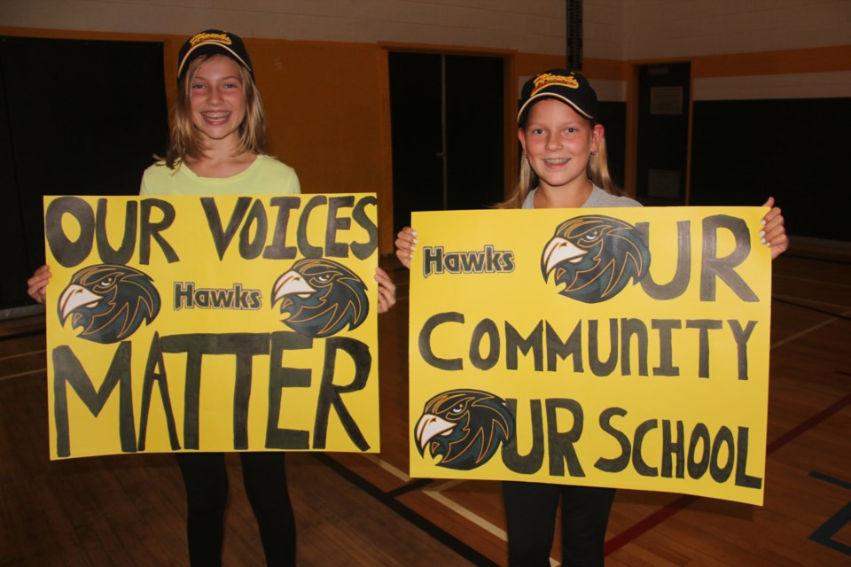Grade 7 Lively District Secondary School students MacKenna Tomlinson (left) and Miia Hanhimaki made signs in support of their school, which may close next year. Photo by Heidi Ulrichsen.