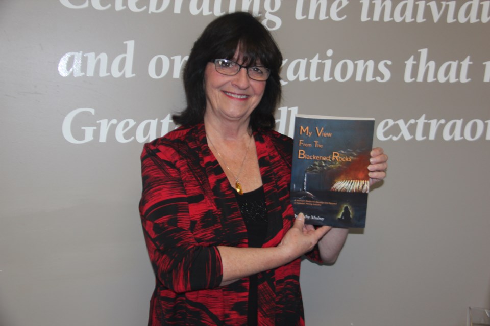 Cathy Mulroy with her book “My View from the Blackened Rocks.” (Heidi Ulrichsen/Sudbury.com) 