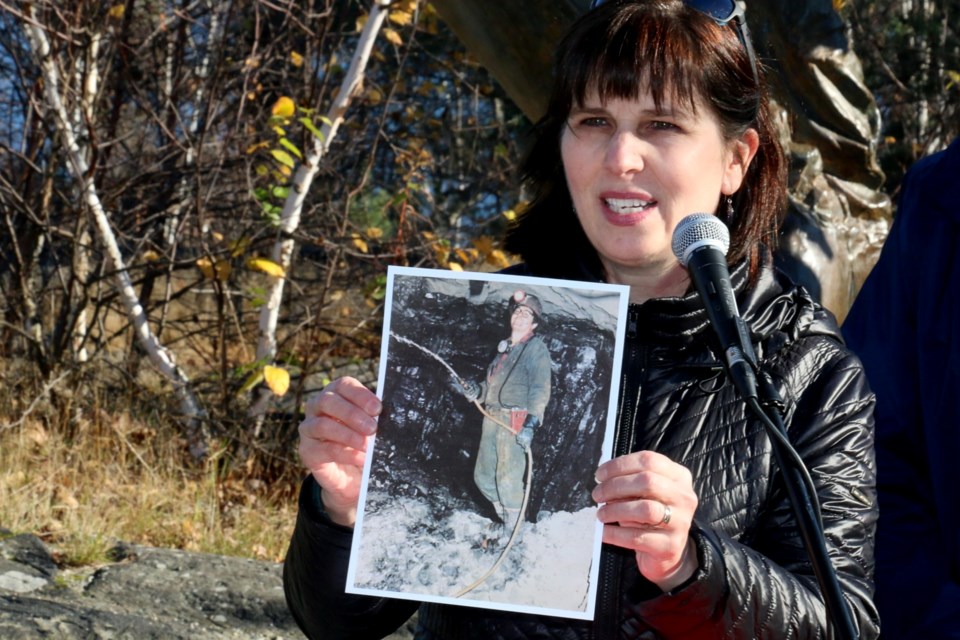 Janice Hobbs Martel held up a photograph of Timmins miner Isadore Commando, who died in May. Martell, who spoke at a news conference Tuesday,  said Commando was one of dozens of hard rock miners who have died in recent years. Martell said Commando was on the list of miners who had been forced to inhale McIntyre Powder as a condition of work. 