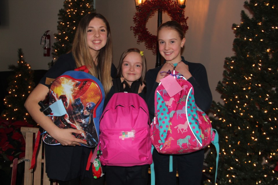 The Sudbury Christian Academy school community has filled 40 backpacks with presents for clients of the Elgin Street Mission. Many of the bags are intended for kids. From left are Grade 8 student Abigail Glass, Grade 4 student Satine Stanfield and Grade 5 student Teia Kolari. Photo by Heidi Ulrichsen.