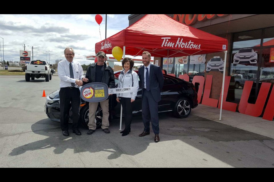 Chelmsford resident Robert Cornett (second from left) claimed his new Honda Civic on May 9 after winning the car on Roll Up the Rim to Win. Presenting him with is key is Chelmsford Tim Hortons owners Randy (left) and Kelly Annett and Honda GM Lee Mulligan. (Arron Pickard)