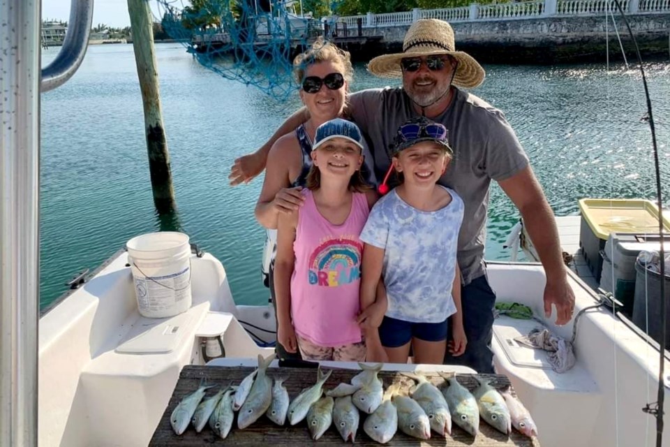 Luke Booker and Shelly Werner and their two kids, McKenna (left) and Kinley, show off a good haul of fish. The Sudbury family spent a year travelling the Great Loop on their 47-foot boat, the Oh Henry. 