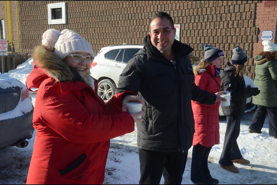 Cedar Nest owner Sue Peters hands soup to Zaher's Small Batch owner Deke Zaher during the Warm Soup for Warm Hearts event Dec. 10. The two business owners hit on the idea of human chain of soup through the downtown to benefit the Blue Door Soup Kitchen. (Arron Pickard / Sudbury.com)