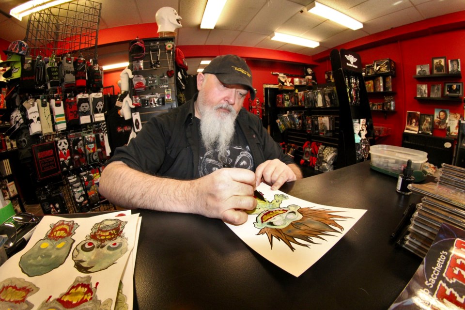 Local artist Rob Sacchetto works on a zombie image during a book signing event at The Gory Hole in downtown Sudbury on Saturday.
