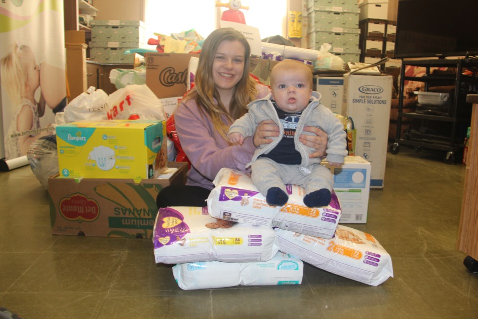 Better Beginnings, Better Futures' Baby's Breath teen parenting program participant Phoenix Ellis, 19, and her son Xavier, 3 months, show off some of the donations of baby supplies that have been made to the program. The donations were as a result of a fill-a-playpen initiative run by local Club Richelieu chapters. (Heidi Ulrichsen/Sudbury.com)