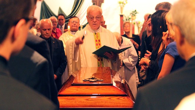 Msgr. James Hutton blesses the coffin at the funeral for John Rodriguez on July 11. (Arron Pickard/Sudbury.com)