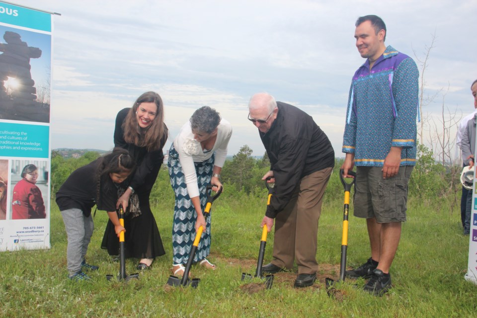 University of Sudbury president Sophie Bouffard (left) laughs as young Wii'um Morin helps her break ground on a sacred fire arbour that will be built on the federated university's grounds. Joining her are (from left) board of regents chair Joseé Forest-Niesing, chancellor Gérald Michel and indigenous studies professor Brock Pitawanikwat. (Heidi Ulrichsen/Sudbury.com)