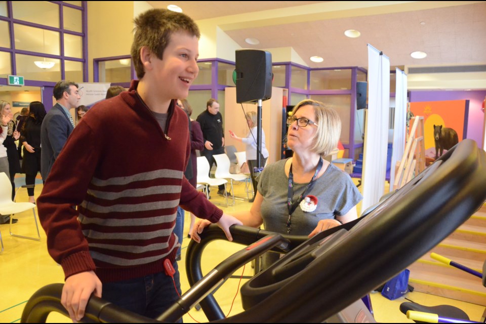 Children's Treatment Centre client Bennett Burke tries out the treadmill in the Smilezone with the help of his physiotherapist, Mary Sabo. (Arron Pickard)
