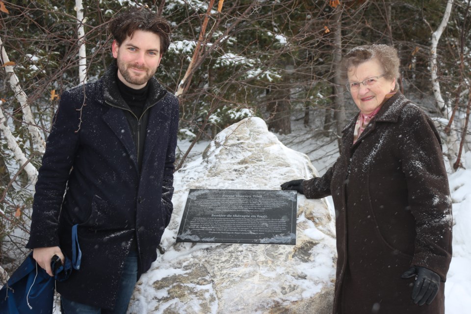 Lea Curridor, wife of the late Giuseppe “Beppi” Curridor and Students' General Association president Eric Chappell, show off the plaque dedicating Beppi’s Forest Therapy Trail. (Heidi Ulrichsen/Sudbury.com)