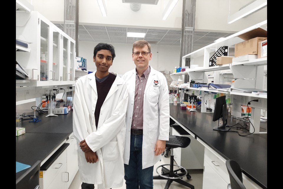 Aaryan Harshith, at left, has developed a device that he said can detect cancer cells far more quickly than any conventional device. Harshith, who is 14, moved from the Ottawa area with his parents this summer and will soon be attending Grade 10 in Sudbury. In this photo he was with Dr. Martin Holcik of Carleton University. (Photo Supplied)
