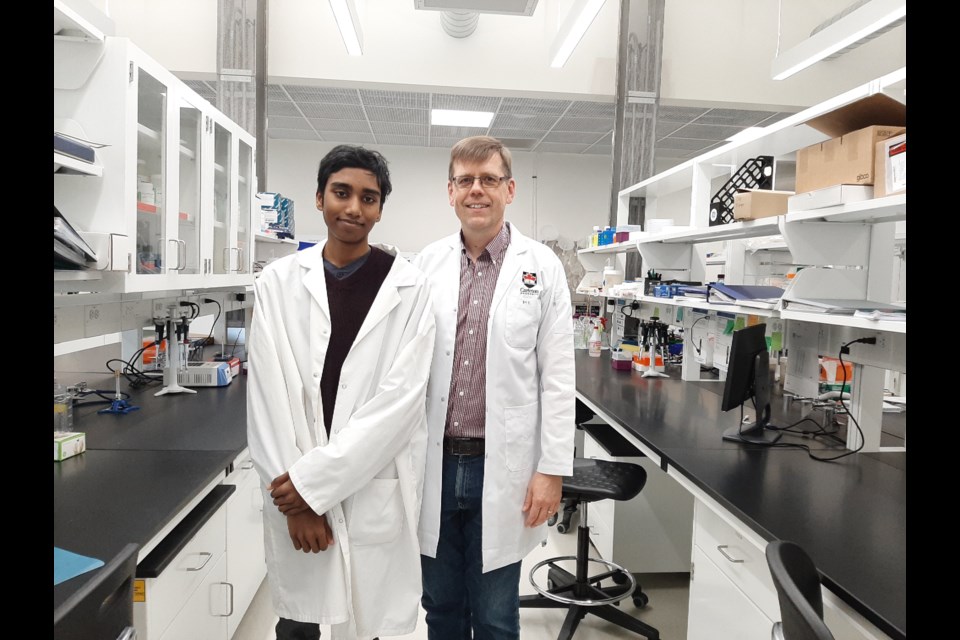 Aaryan Harshith, at left, has developed a device that he said can detect cancer cells far more quickly than any conventional device. Harshith, who is 14, moved from the Ottawa area with his parents this summer and will soon be attending Grade 10 in Sudbury. In this photo he was with Dr. Martin Holcik of Carleton University. (Photo Supplied)