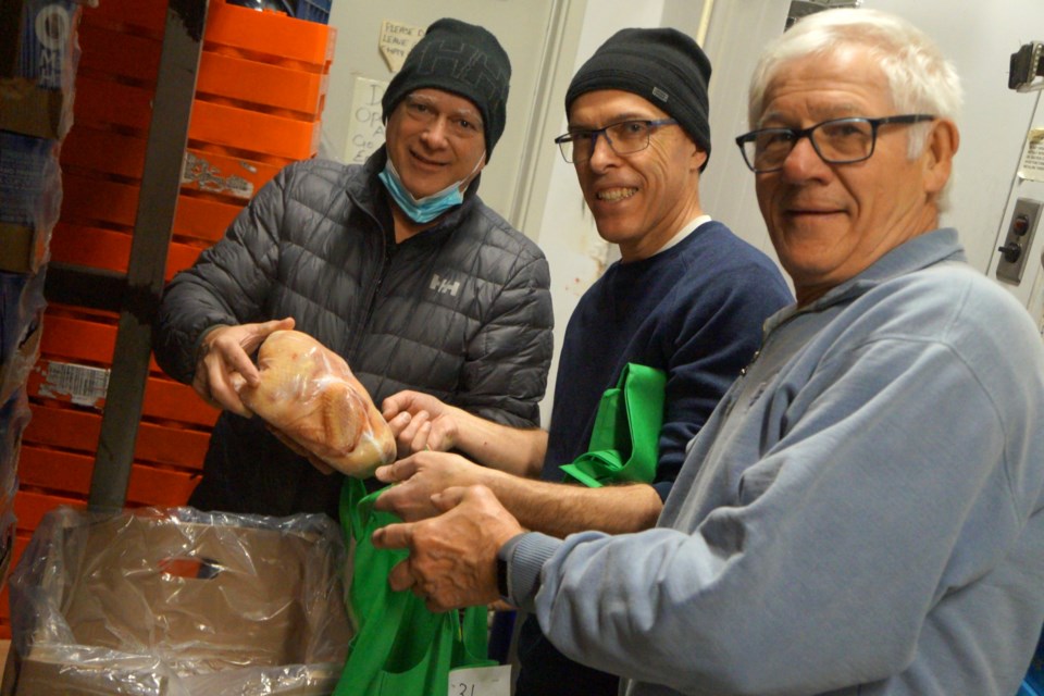 Putting together Christmas baskets for distribution on Dec. 17 are Club Richelieu Les Patriotes members (from left) Raymond Coutu, Yves Fortin and Michel Rainville. 
