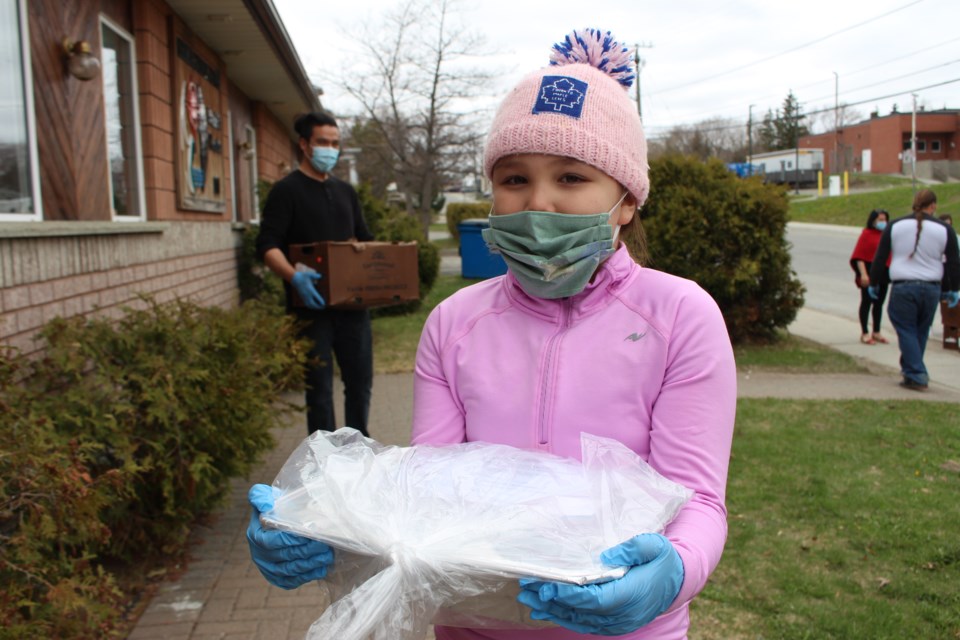 Zaagidwin Peltier, seven-years-old but nearly eight, helping unload a special delivery from Pasta it Forward for Shkagamik-Kwe Health Centre. (Keira Ferguson/ Sudbury.com)