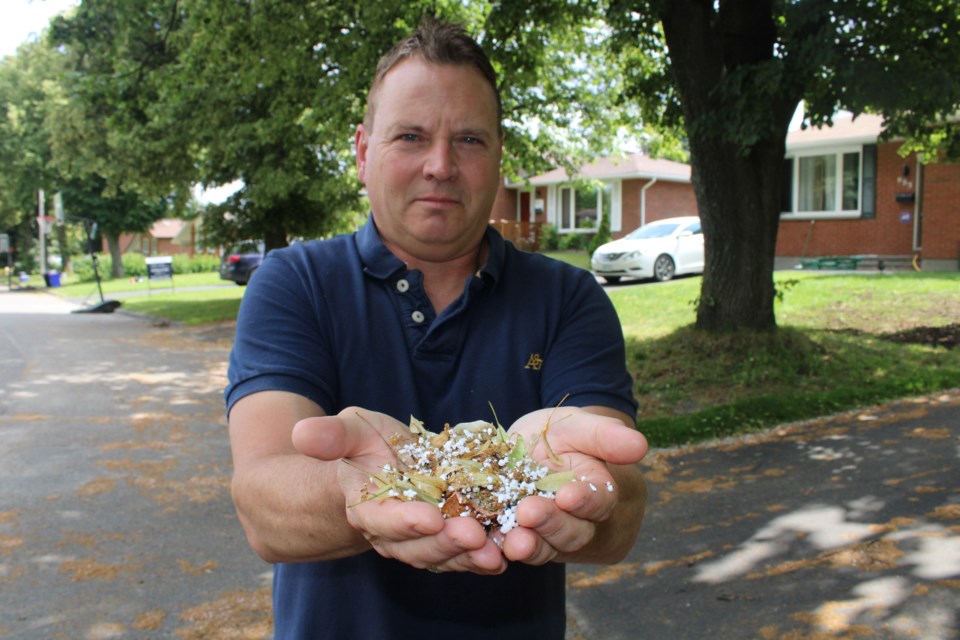 Minnow Lake neighbourhood resident Kevin Cooper is seen with a pile of debris from the gutter on Camelot Drive, which includes a pile of polystyrene foam (best known by its brand name of Styrofoam) fragments.