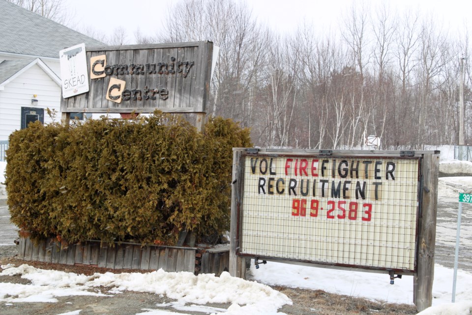 A sign outside the Skead Community Centre advertises the need for volunteer firefighters.