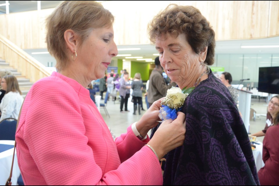 Nickel Belt MPP France Gélinas pins a corsage on Mary Carter, one of the first women to graduate from  Laurentian University’s School of Nursing. LU held a 50th anniversary of the School of Nursing on Saturday. (Arron Pickard)
