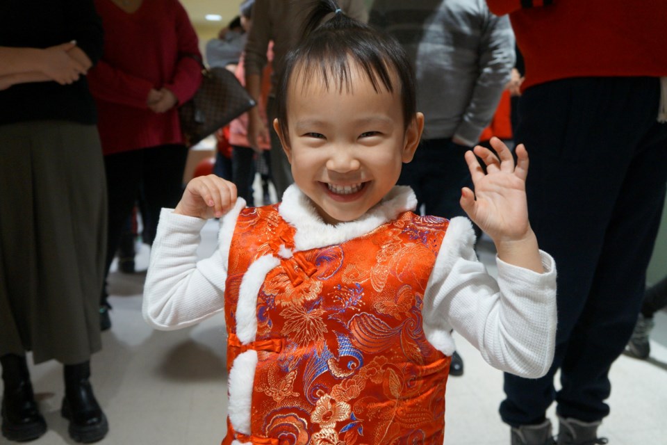 At Lunar New Year celebrations in Sudbury on Jan. 21 organized by the Chinese Heritage Association of Northern Ontario, three-year-old Avery waits in line for the Chinese New Year feast, wearing a traditional HanMing.