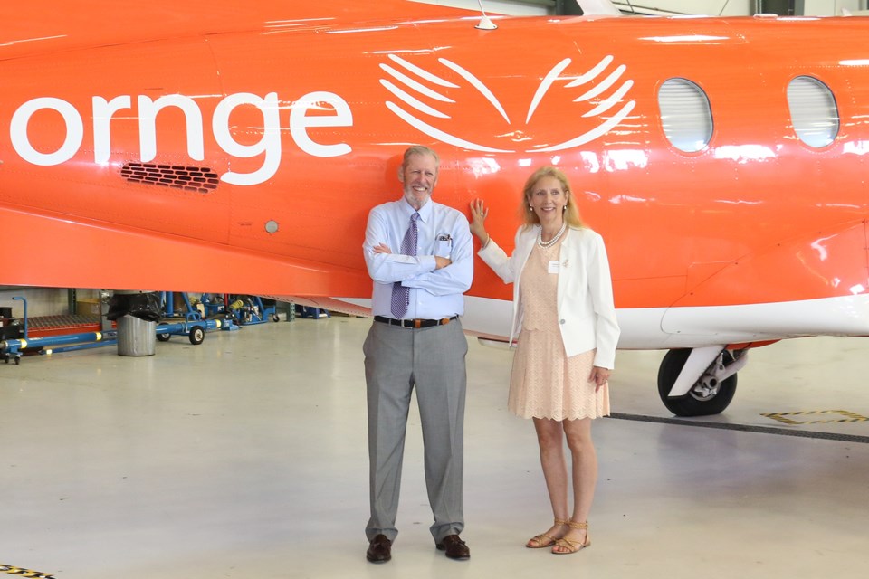 Ornge board chairman Ian W. Delaney, left, stands next to a Pilatus PC12 aircraft with Nickel Belt MPP France Gélinas at the company's new hangar at the Greater Sudbury Airport. 