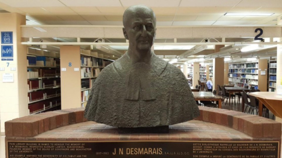 The bust of J.N. Desmarais, the namesake of the library at Laurentian University, has undergone some scrutiny because the family bus company Desmarais owned was replaced by a public system because its buses were so decrepit more than 20 students were hospitalized after inhaling exhaust fumes. Eventually the Desmarais’ company moved to Quebec where the family became multi-millionaires involved in other scandals. (Laurentian University)