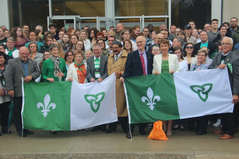 Dignitaries and students gather for a photo outside of the University of Sudbury with the Franco-Ontarian flag Sept. 25. (Heidi Ulrichsen/Sudbury.com)