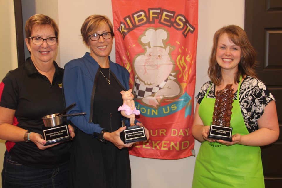 (From left) Downtown Sudbury executive director Maureen Luoma, YMCA of Northeastern Ontario president and CEO Helen Francis and reThink Green communications director Leigha Benford show off the Ribfest Sudbury trophies. (Heidi Ulrichsen/Sudbury.com)