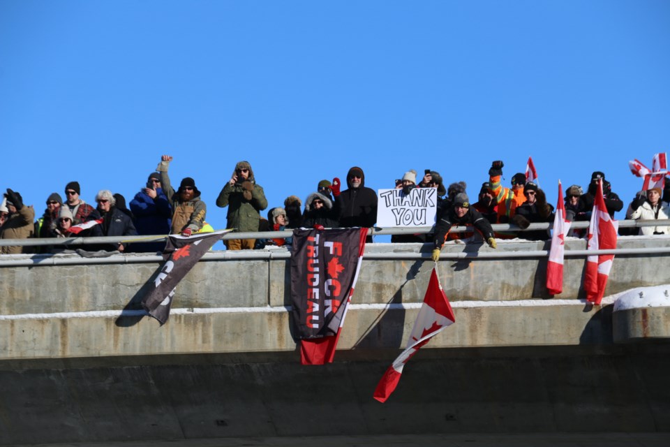Supporters stretch across the Highway 144 overpass across Highway 17 to cheer on the Convoy to Ottawa 2022 on Friday.