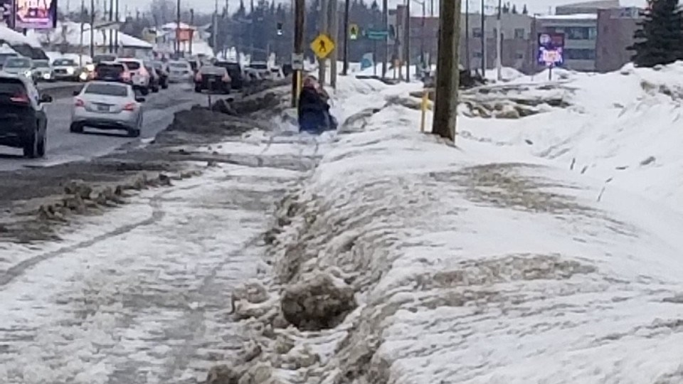 Marc Pleau shared this photo of a wheelchair user trying to navigate an icy, slushy sidewalk along a busy thoroughfare.  “Meanwhile, the roadway is entirely clear and bare,” he stated.