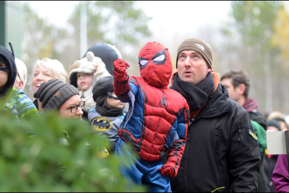 Four-year-old Luke Genoe and his dad, Doug Donald Genoe, watch excitedly as Wolverine rappels down the side of Health Sciences North as part of Superheroes for Little Heroes.  (Arron Pickard/Sudbury.com)
