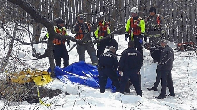 Emergency responders remove a body found in Junction Creek off Riverside Drive on April 11. (Arron Pickard / Sudbury.com)