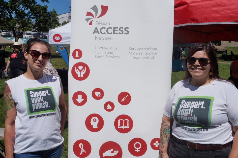 Amber Fritz (left), manager of The Spot, Sudbury’s supervised consumption site, stands with Kaela Pelland (right), at the Support, Don’t Punish Global Day of Action in Memorial Park on June 28.  