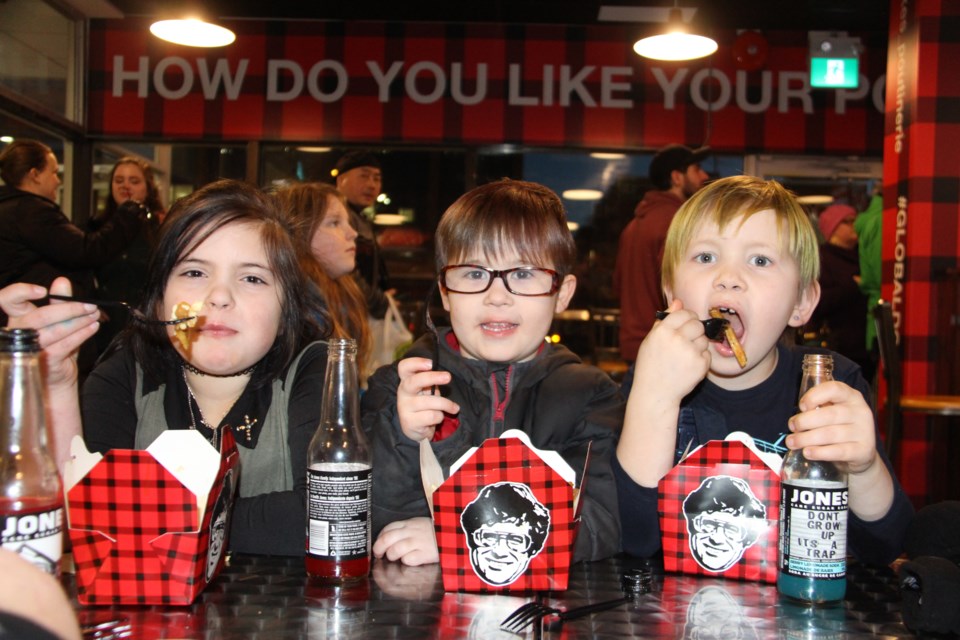 Paige, Freya, and Sawyer Vokey dig into some poutine at Smoke's Poutinerie Friday evening. The restaurant officially opened to the public on Jan. 13. Photo: Matt Durnan