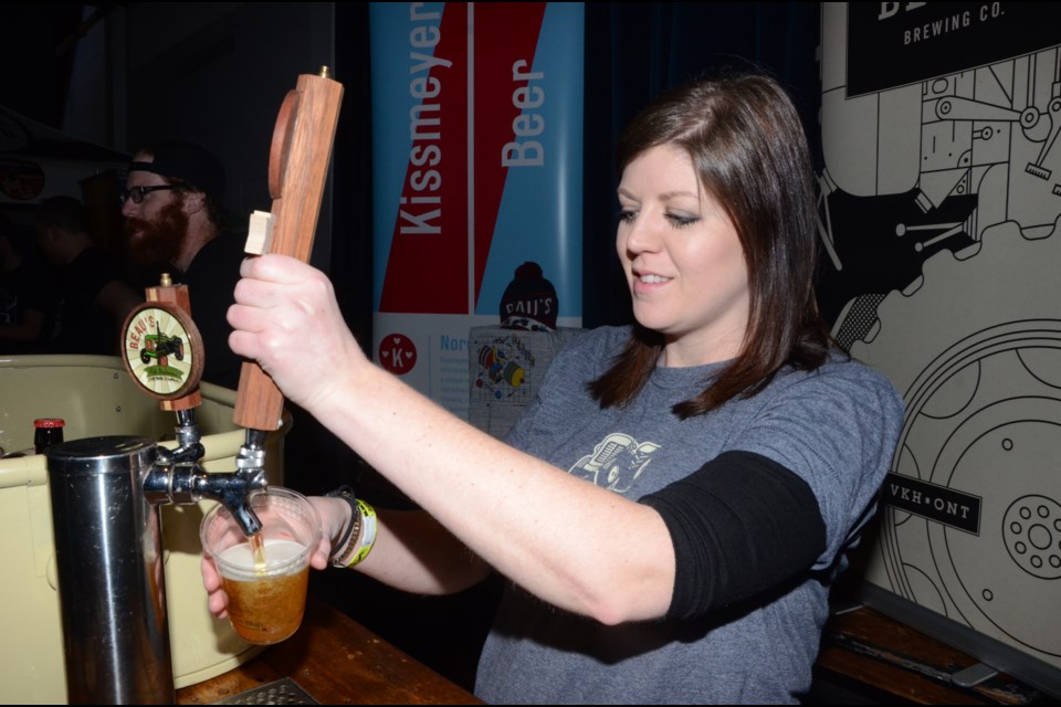 Jackie Bird, of  Beau's All Natural Brewery, pours a glass at the Northern Ontario Microbrew Festival on Saturday.