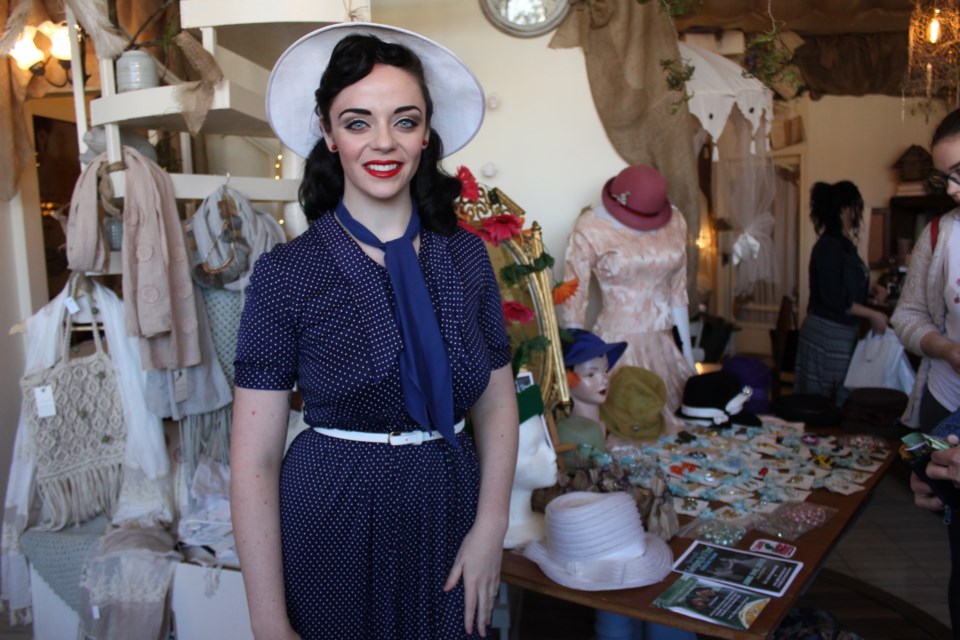 Sporting a classic blue dress with white polka dots and a matching hat, Starlotte Satine channels vintage chic at a pop-up shop at Cedar Nest recently. Her vintage pop-up shop, Starlotte Satine Fashions, is your connection to classic mid-20th century fashion. (Ella Jane Myers)