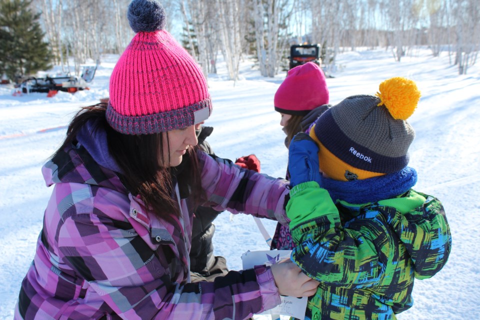 Jacob Roy having his race number attached by mom, Kyla Roy, at Kivi Park for the Move fitness series' Snowshoe Trek for Cancer (Keira Ferguson/ Sudbury.com)