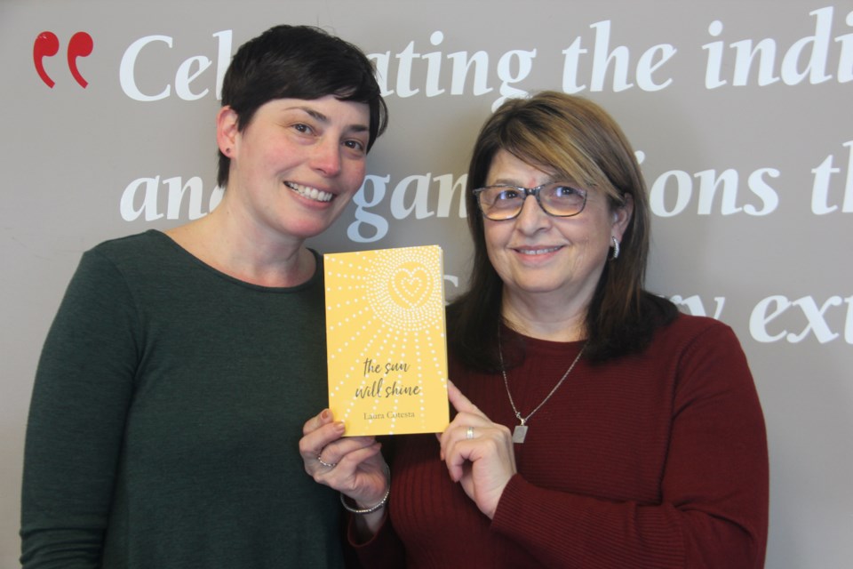 Laura Stradiotto and Pina Cotesta with the book “The Sun Will Shine,” featuring writing by Laura Cotesta, who died in 1997 at age 18 after living with a rare spinal cancer for 10 years. (Heidi Ulrichsen/Sudbury.com)