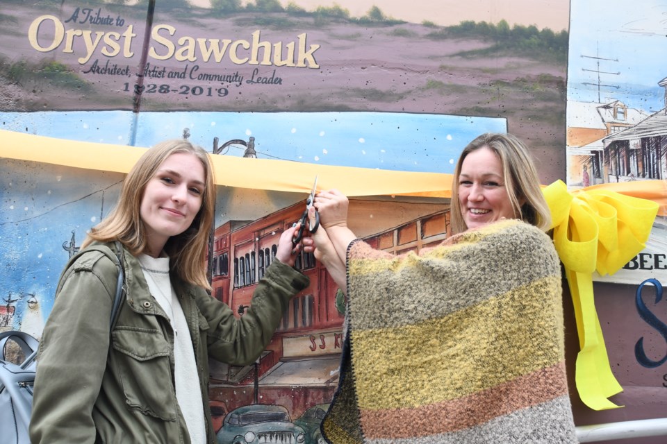 Lauren Calson (left) who assisted professional artist Monique Legault (right) with the creation of a mural honouring the late Oryst Sawchuk, in the underpass connecting Elgin Street and Riverside Drive. (Marg Seregelyi/ Sudbury.com)