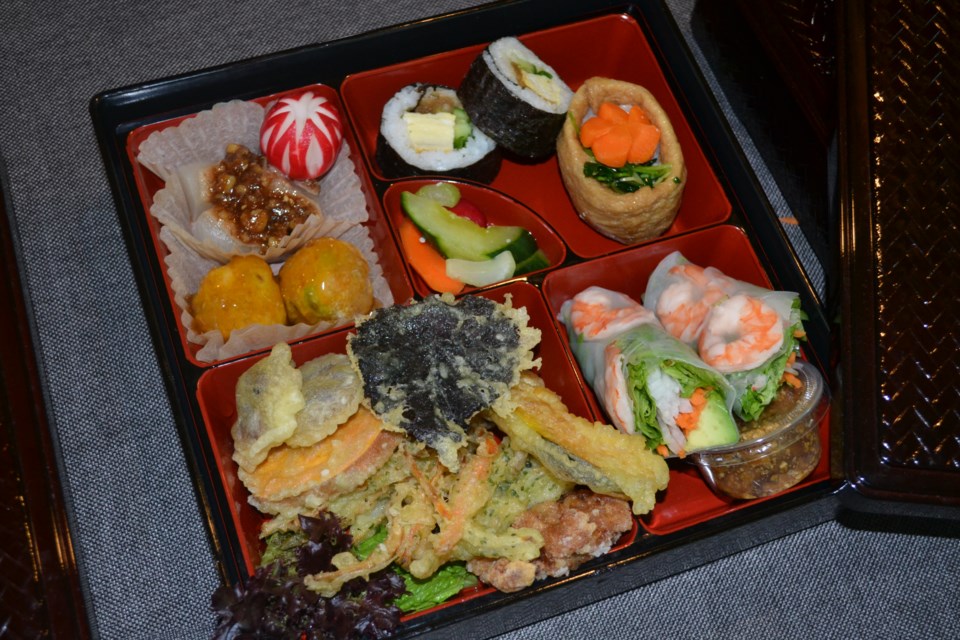 A sample bento box features rolls, tempura, beautifully crafted daikon summer radishes and pumpkin squash balls. These boxes are recyclable and refillable when ordered from the Nickel Refillery.
